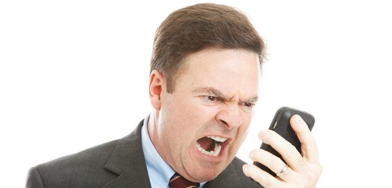 Angry businessman yelling into a cellphone.